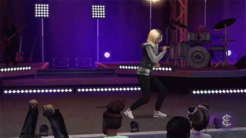 A Woman Singing On Stage In Front Of A Drum Set With Nk On It GIF