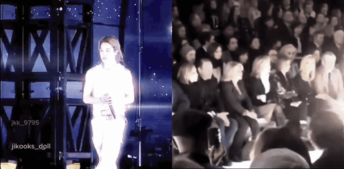 A Woman Singing On Stage Next To A Group Of People GIF