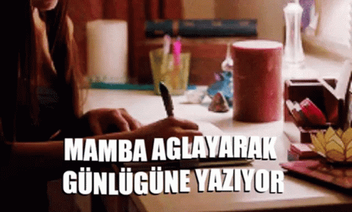 a woman sits at a desk writing in a notebook and the words mamba aglayarak gunlugune yaziyor are above her