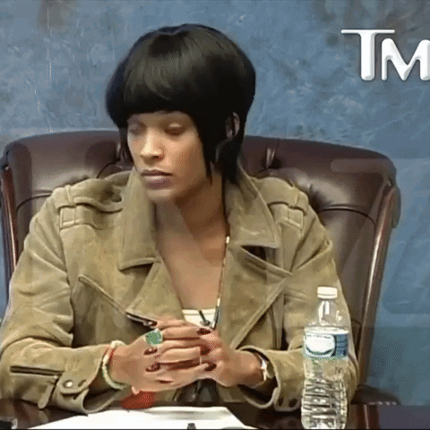 A Woman Sits At A Table With A Bottle Of Water And A Tm Logo GIF