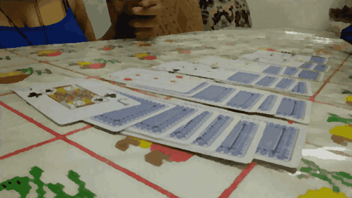 A Woman Sits At A Table With A Bunch Of Playing Cards GIF