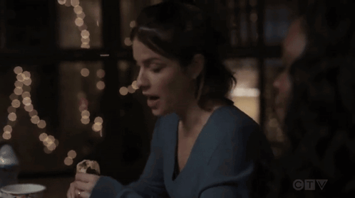 A Woman Sits At A Table With A Cup Of Coffee And A Ctv Logo In The Corner GIF