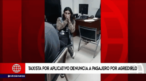 A Woman Sits In A Chair In Front Of A Desk With A Red Background That Says Taxista GIF