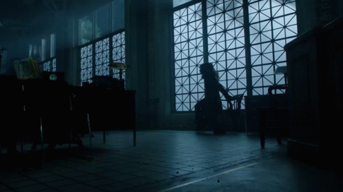 A Woman Sits In A Chair In Front Of A Large Window GIF