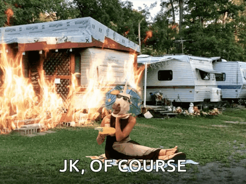 A Woman Sits In Front Of A Burning Trailer With The Words " Jk Of Course " Written Below Her GIF