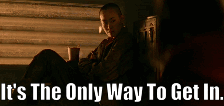 A Woman Sits In Front Of A Window With The Words " It 'S The Only Way To Get In " Above Her GIF