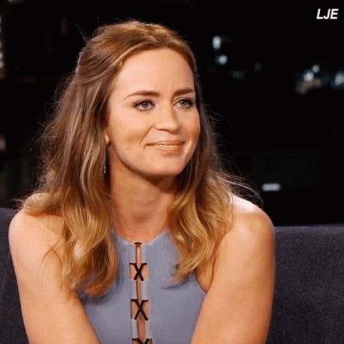 A Woman Sits On A Couch With The Letters Lje On The Bottom Right GIF