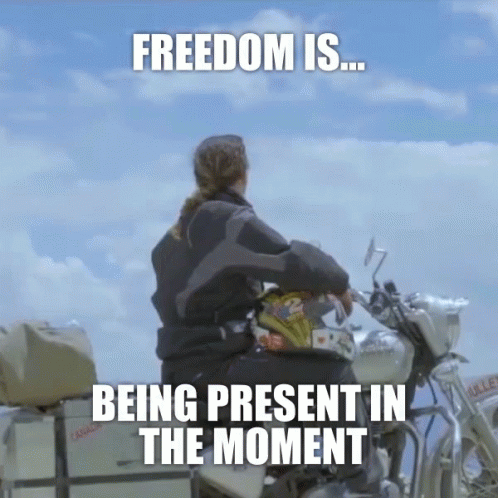 A Woman Sits On A Motorcycle With The Words " Freedom Is Being Present In The Moment " GIF
