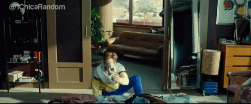 A Woman Sits On The Floor In A Living Room With The Words @ 1Chica Random Written Above Her GIF