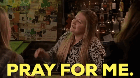 A Woman Sitting At A Bar With The Words Pray For Me On The Screen GIF