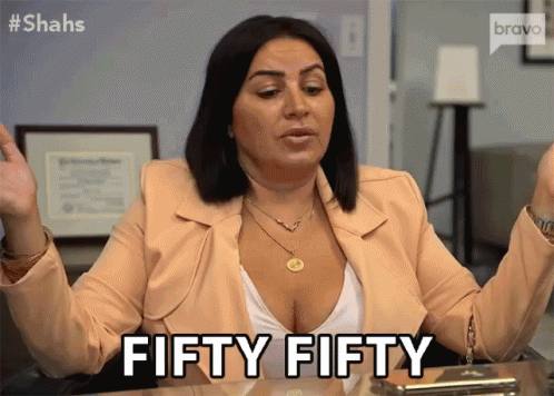 A Woman Sitting At A Desk Says Fifty Fifty With Her Hands In The Air GIF
