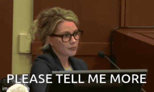 A Woman Sitting At A Desk With A Microphone And The Words Please Tell Me More GIF