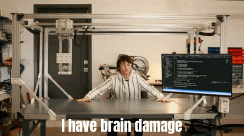 A Woman Sitting At A Desk With The Words I Have Brain Damage On The Bottom GIF