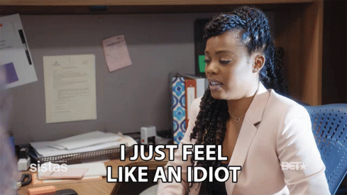 A Woman Sitting At A Desk With The Words I Just Feel Like An Idiot GIF