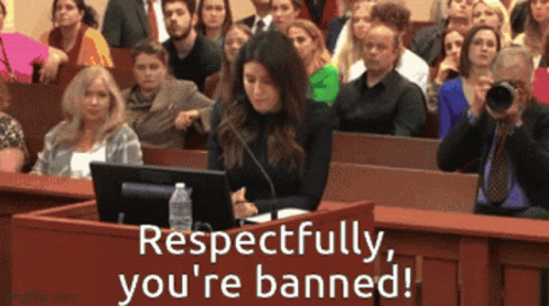 A Woman Sitting At A Podium In Front Of A Crowd With Respectfully You 'Re Banned GIF