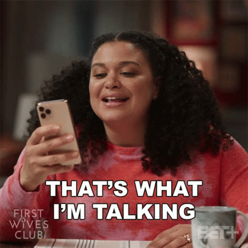 A Woman Sitting At A Table Looking At Her Phone With The Words That 'S What I 'M Talking Below Her GIF