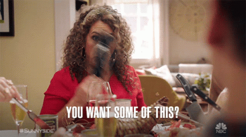 A Woman Sitting At A Table With A Glass Of Wine Says You Want Some Of This . GIF