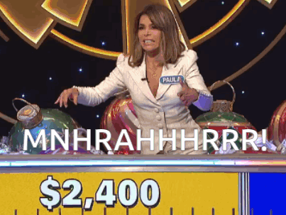 A Woman Sitting At A Table With A Sign That Says $ 2,400 On It GIF