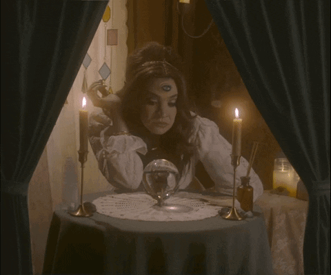A Woman Sitting At A Table With Candles And The Words The Audacity GIF