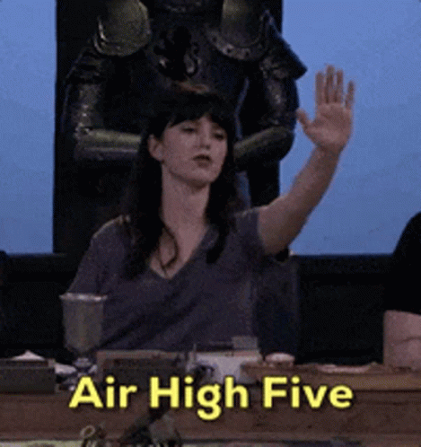 A Woman Sitting At A Table With Her Hand Up And The Words Air High Five GIF