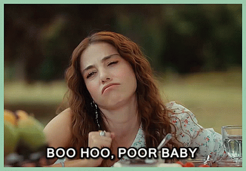 A Woman Sitting At A Table With The Words Boo Hoo Poor Baby Written Below Her GIF