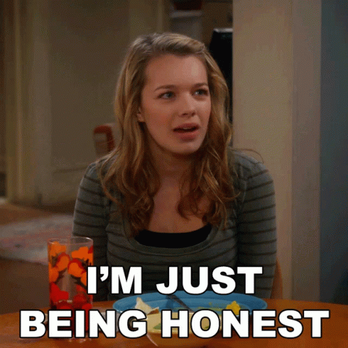 A Woman Sitting At A Table With The Words I 'M Just Being Honest Written Below Her GIF