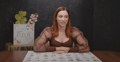 A Woman Sitting At A Table With The Words " No-One Is Complaining " Above Her GIF