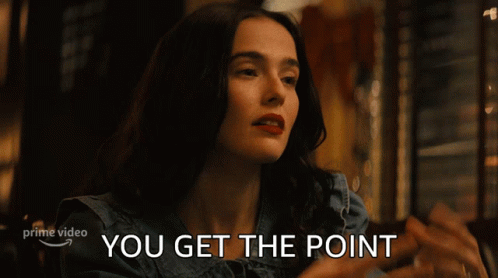 A Woman Sitting At A Table With The Words " You Get The Point " Written Below Her GIF