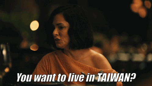 A Woman Sitting At A Table With The Words " You Want To Live In Taiwan " GIF