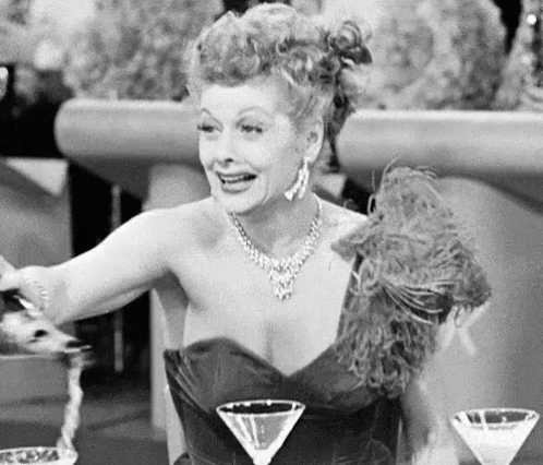 A Woman Sitting At A Table With Three Martini Glasses In Front Of Her GIF