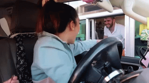 A Woman Sitting In A Car Talking To A Man GIF