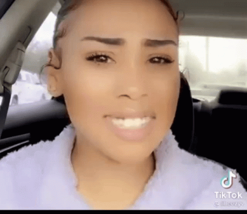 A Woman Sitting In A Car With A Tiktok Watermark On The Bottom Right GIF