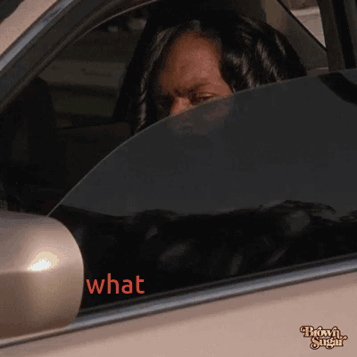 A Woman Sitting In A Car With The Word What Written On The Window GIF