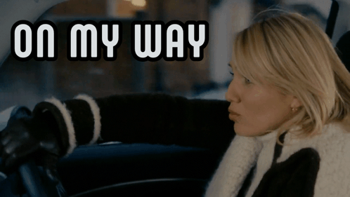 A Woman Sitting In A Car With The Words On My Way Behind Her GIF