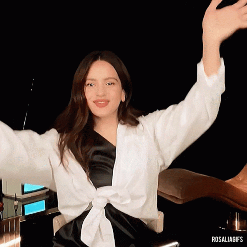 A Woman Sitting In A Chair With Her Arms Outstretched And The Hashtag Rosaliagifs GIF