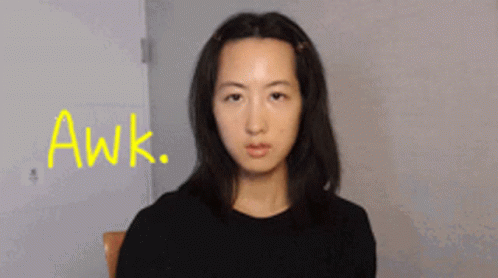 A Woman Sitting In A Chair With The Word Awk Written In Yellow GIF