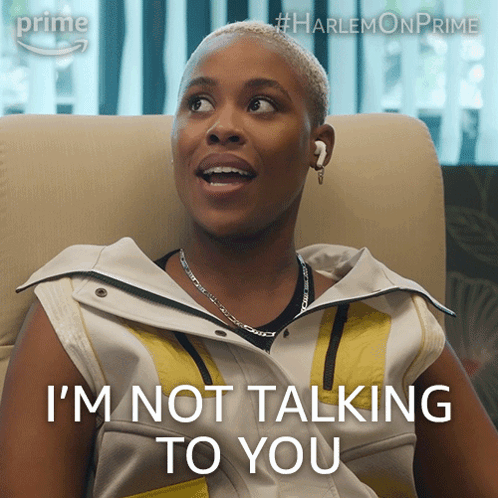 A Woman Sitting In A Chair With The Words " I 'M Not Talking To You " On Her Face GIF