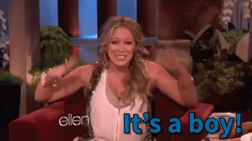 A Woman Sitting In A Chair With The Words " It 'S A Boy " On The Bottom GIF