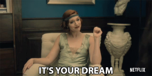 A Woman Sitting In A Chair With The Words " It 'S Your Dream " Written On The Screen GIF