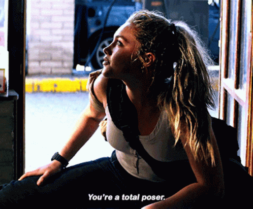 A Woman Sitting In A Doorway With The Words You 'Re A Total Poser GIF