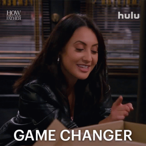 A Woman Sitting In Front Of A Cardboard Box With The Words Game Changer On Her Face GIF