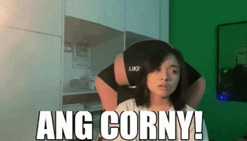 A Woman Sitting In Front Of A Green Wall With The Words Ang Corny On It GIF