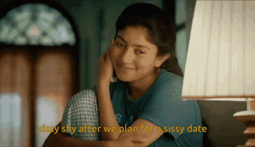 A Woman Sitting In Front Of A Lamp With The Words Sissy Shy After We Plan For A Sissy Date Below Her GIF