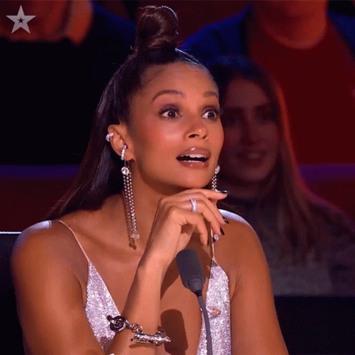 A Woman Sitting In Front Of A Microphone With A Star On The Bottom Left GIF