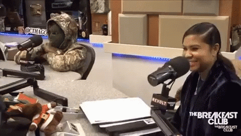 A Woman Sitting In Front Of A Microphone With The Breakfast Club Written On The Front GIF