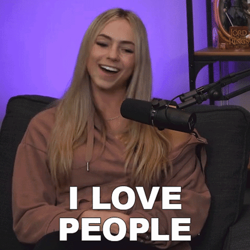 A Woman Sitting In Front Of A Microphone With The Words " I Love People " Above Her GIF