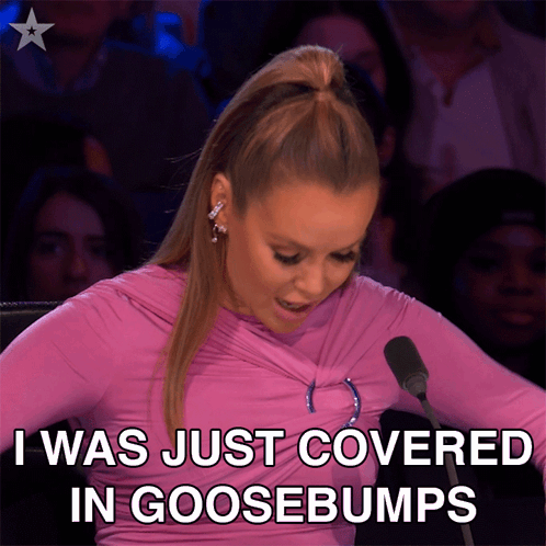 A Woman Sitting In Front Of A Microphone With The Words " I Was Just Covered In Goosebumps " GIF