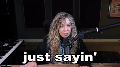 A Woman Sitting In Front Of A Microphone With The Words Just Sayin ' Below Her GIF