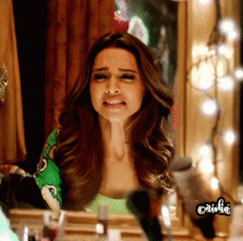 A Woman Sitting In Front Of A Mirror With The Word Olivia On The Bottom Left GIF