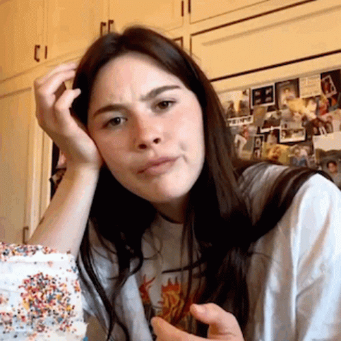A Woman Sitting In Front Of A Refrigerator With A Picture Of A Man On It That Says ' A ' On It GIF
